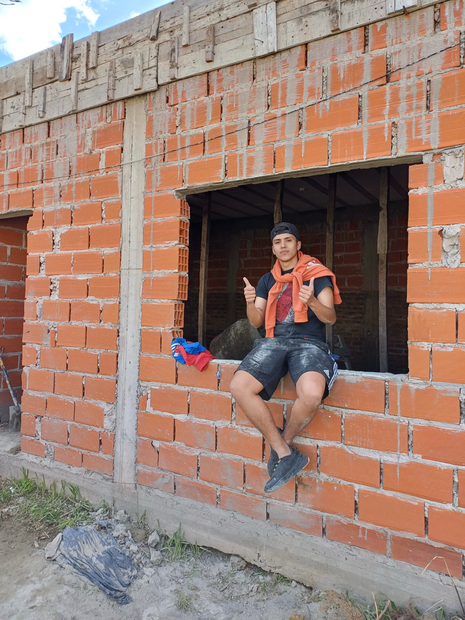 Nahuel sentado en la ventana de una construcción, antes de conocer el trading y el marketing digital